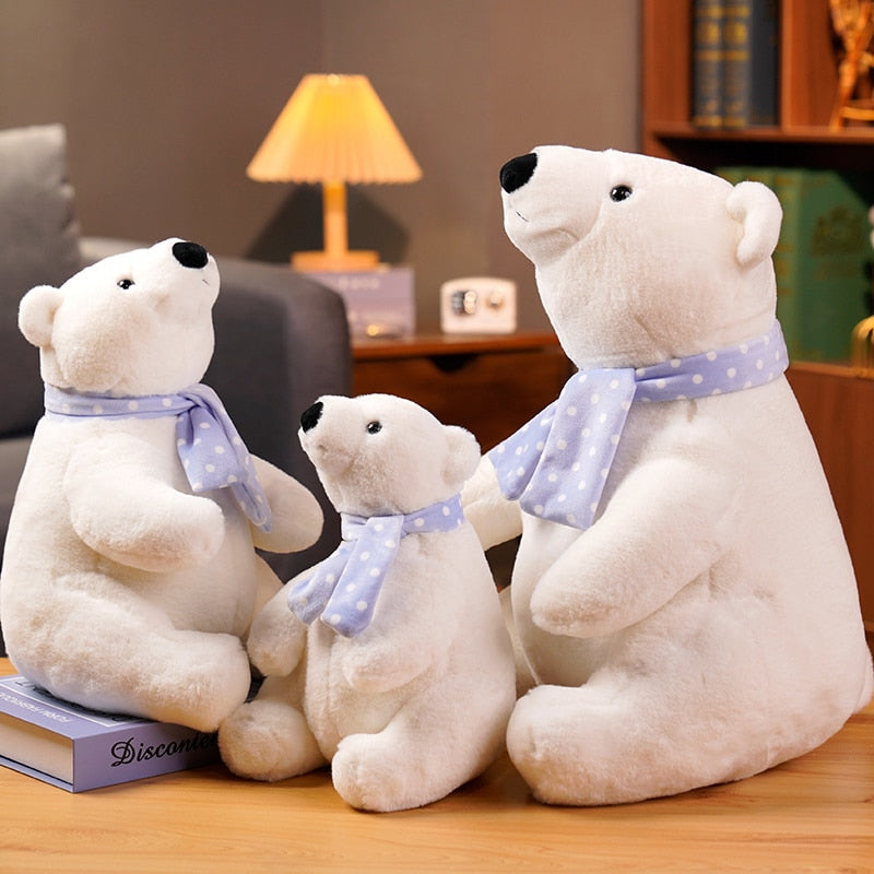 three very cute white polar bears, each wearing a blue scarf with white polka dots.